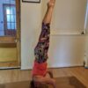 a woman doing a head stand while teaching yoga